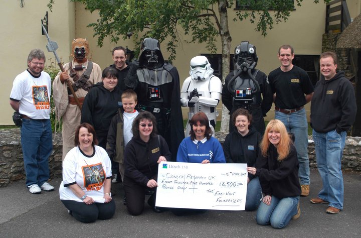 The Exewing Fundraisers presenting a cheque to Cancer Research UK